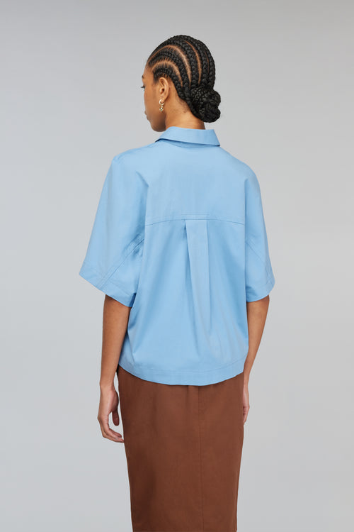 camisa azul. es una prenda de vestir muy común y versátil que puede combinarse con diferentes estilos y colores. la camisa azul es un básico que no puede faltar en el armario de cualquier persona. - Semicouture